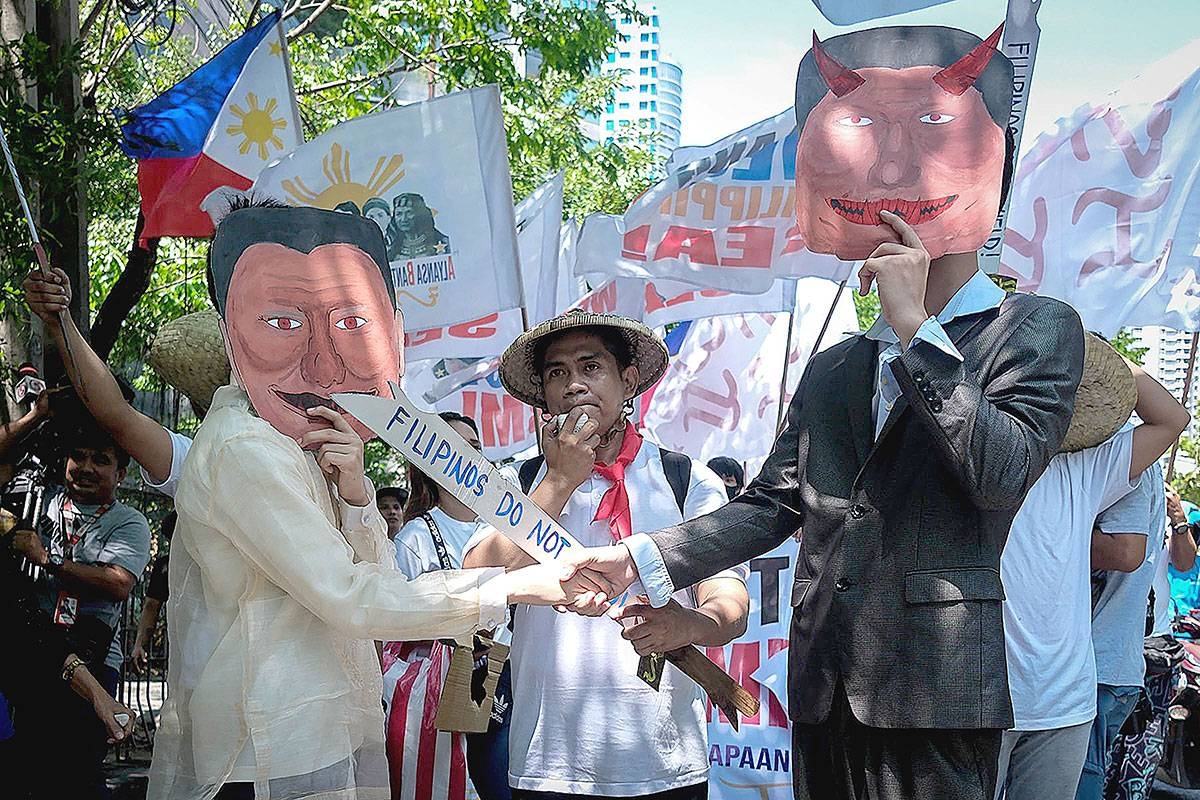 ‘GENTLEMAN’S AGREEMENT’ Protesters from the Alyansa Bantay Kapayapaan at Demokrasya show the ‘handshake’ between then-president Rodrigo Duterte and Chinese President Xi Jinping that apparently sealed a ‘gentleman’s agreement’ in which the Philippines and China will not take action in the West Philippine Sea (WPS) despite a 2016 arbitral ruling that allowed the Philippines to utilize marine resources within its exclusive economic zone. The protest took place in front of the Chinese Embassy in Makati City on Friday, April 19, 2024. PHOTO BY RENE H. DILAN