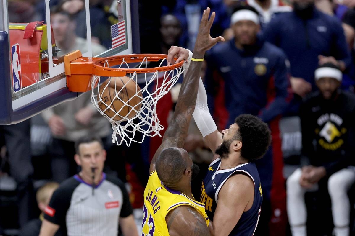 Jamal Murray (27) of the Denver Nuggets dunks on LeBron James (23) of the Los Angeles Lakers in the fourth quarter during game five of the Western Conference First Round Playoffs at Ball Arena on April 29, 2024 in Denver, Colorado. AFP PHOTO