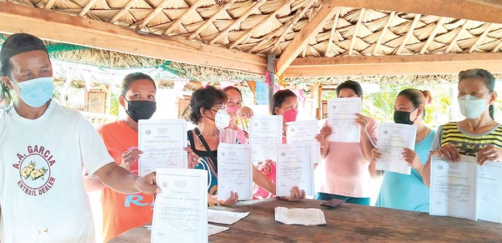 These residents of Barangay Guinob-an, Lawaan, Eastern Samar are seeking the help of Sen. Christopher Lawrence ‘Bong’ Go after they were removed from the list of beneficiaries for the P5.2 million financial assistance given by President Rodrigo Duterte to the indigent residents of Lawaan. They are seen here showing their certificates of indigency issued by their respective barangay. The program offers P3,000 aid to each beneficiary. PHOTO BY NESTOR ABREMATEA