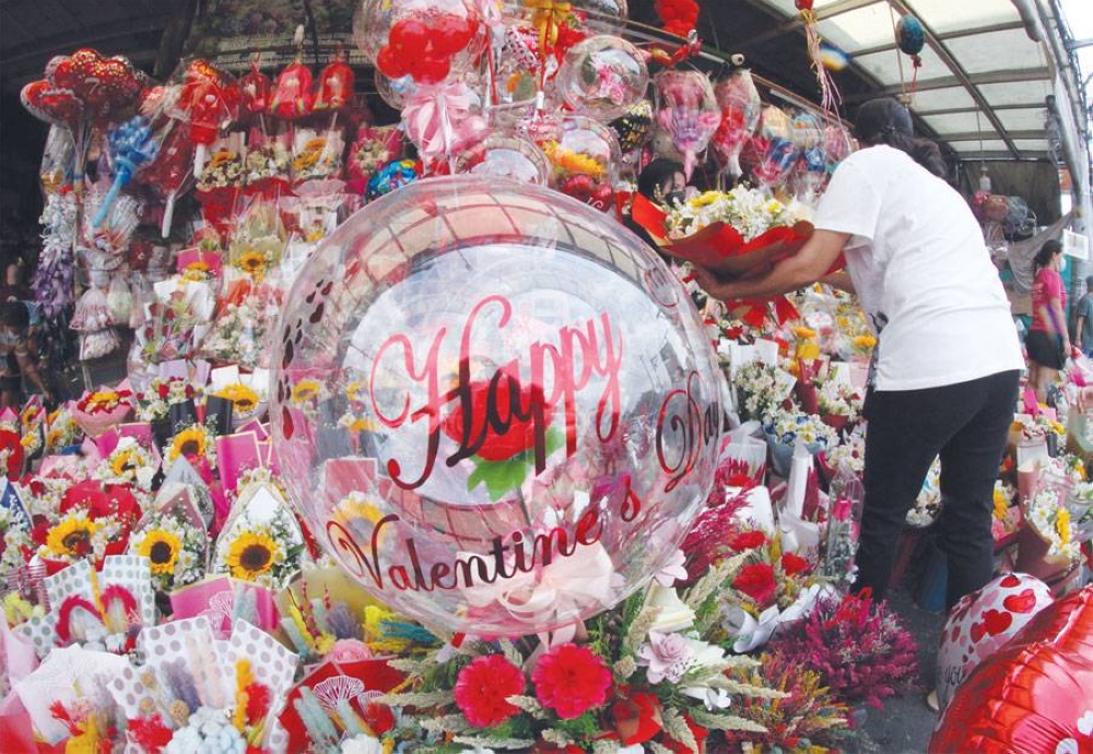 Vendors along Dangwa Flower Market in Sampaloc, Manila arrange their blooms on Saturday, Feb. 12, 2022, in anticipation of customers who will be flocking to their stalls ahead of Valentine’s Day on February 14. Sales are expected to be better as the Covid-19 alert level in Metro Manila and parts of the country has been lowered to 2. PHOTO BY RENE H. DILAN