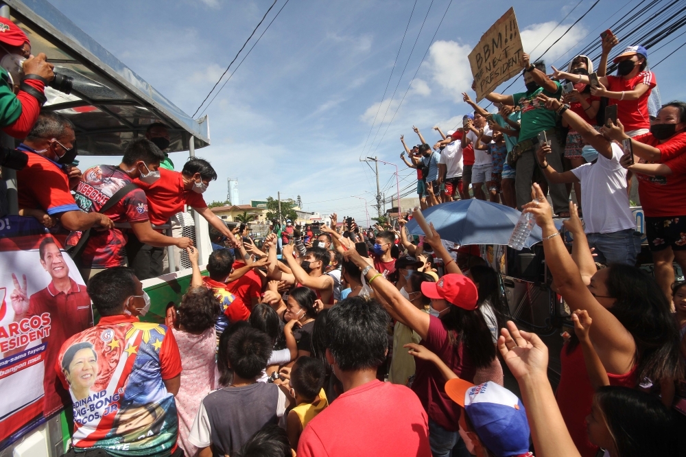 Supporters of presidential aspirant Ferdinand 'Bongbong' Marcos Jr., surround the caravan of the former senator during a campaign sortie in Cavite on Saturday, Feb. 12, 2022. Gov. Juan Victor 'Jonvic' Remulla announced on the same day that the province is behind Marcos and his running mate and Davao City Mayor Sara Duterte-Carpio. PHOTO BY BOY JOSUE