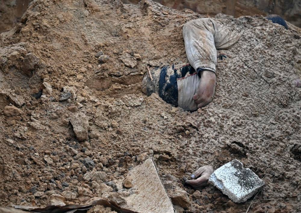 Manos de un cadáver en una fosa común en Bucha, cerca de Kiev, el 9 de abril de 2022. FOTO AFP