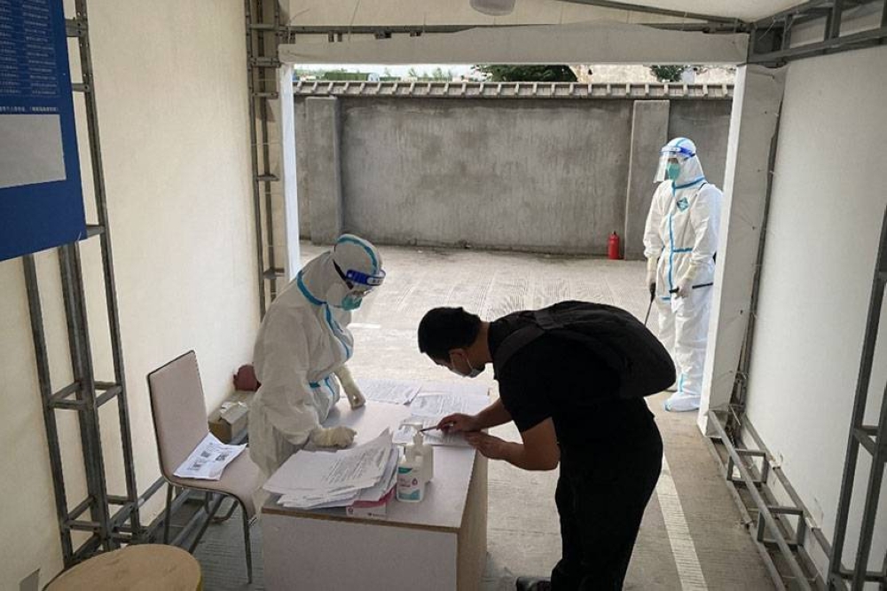 RELEASE ME This June 17, 2022 file photo shows a man signing release documents after finishing 14 days of isolation in a quarantine-designated hotel in Shanghai. AFP PHOTO