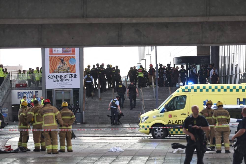 Police officers and rescuers are seen in front of the Fields shopping center in Oerested in Copenhagen, on July 3, 2022, after a shooting took place in the shopping center. AFP PHOTO