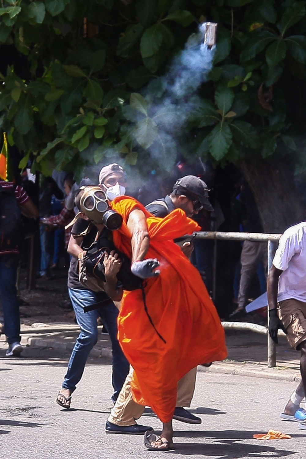 BELLIGERENT A Buddhist monk throws back a tear gas canister fired by the police to disperse protesters demanding the resignation of Sri Lanka’s President Gotabaya Rajapaksa gather near the compound of Sri Lanka’s Presidential Palace in Colombo on Saturday, July 9, 2022. AFP PHOTO
