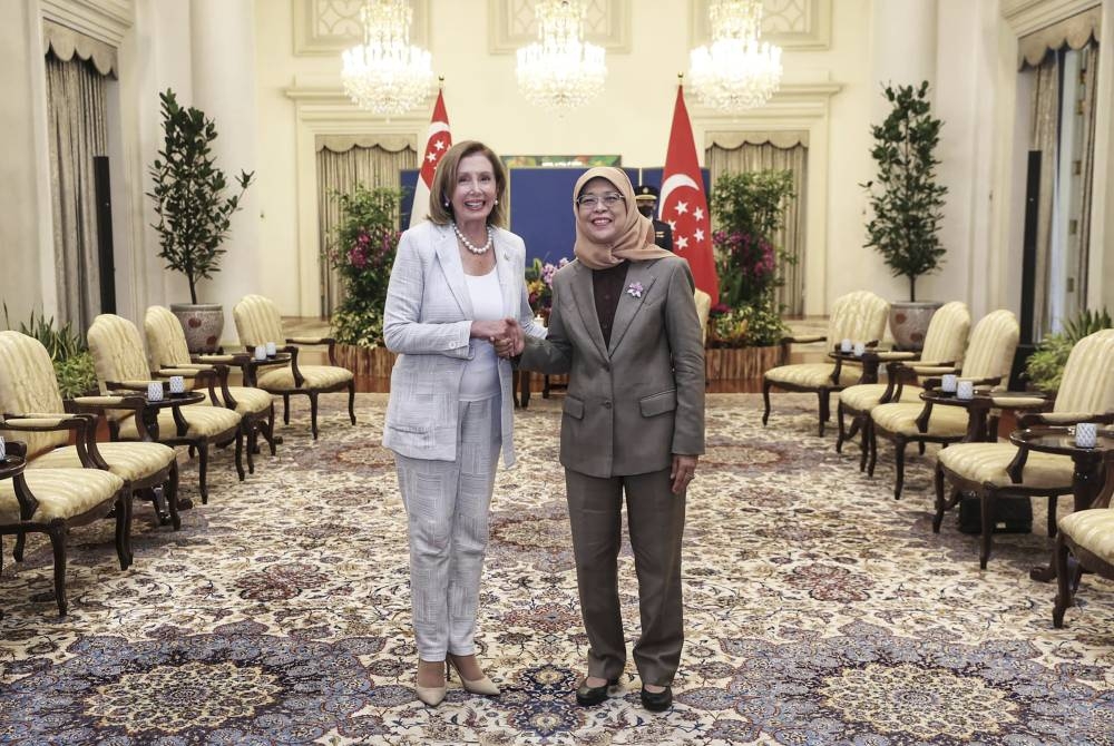 In this photo provided by Ministry of Communications and Information, Singapore, US House Speaker Nancy Pelosi (left) and Singapore President Halimah Yacob shake hands at the Istana Presidential Palace in Singapore, Monday, Aug. 1, 2022. (Ministry of Communications and Information, Singapore via AP)