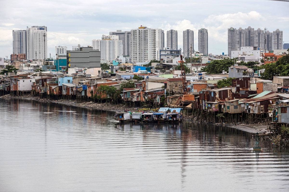 In this file photo taken on September 17, 2018, houses are seen on the banks of the Te canal in Ho Chi Minh City. - Sprawling coastal cities in South and Southeast Asia are sinking faster than elsewhere in the world, leaving tens of millions of people more vulnerable to rising sea levels, a new study says. (Photo by Kao NGUYEN / AFP)