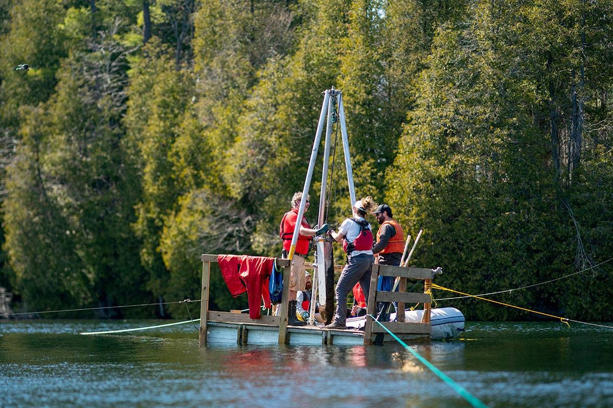 Tim Patterson (L), Professor of Geology at Carleton University, leads a team of scientists as they retrieve a probe from the bottom of Crawford Lake while gathering sediment layer samples at Crawford Lake near Milton, Ontario, Canada, April 12, 2023. The view under the surface of Crawford Lake tells a different story. Scientists believe the lake's exceptionally well-preserved sediment layers serve as a reference point for a proposed new geological chapter in the planet's history, defined by the considerable changes wrought by human activity: the Anthropocene. The International Commission on Stratigraphy's Anthropocene Working Group on July 11, 2023, named the lake as the embodiment of the proposed Anthropocene epoch. Peter POWER / AFP