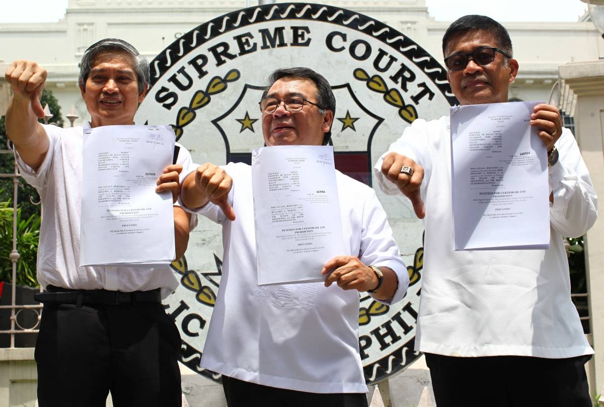 Former party-list representative Neri Colmenares, Bayan Muna Representative Isagani Zarate, and Bayan Muna former representative Ferdinand Gaite, hold up a petition for Certiorari and Prohibition document against Maharlika funds in front of the Supreme Court along Padre Faura in Manila, on Monday, September 18, 2023. PHOTOS BY MIKE ALQUINTO
