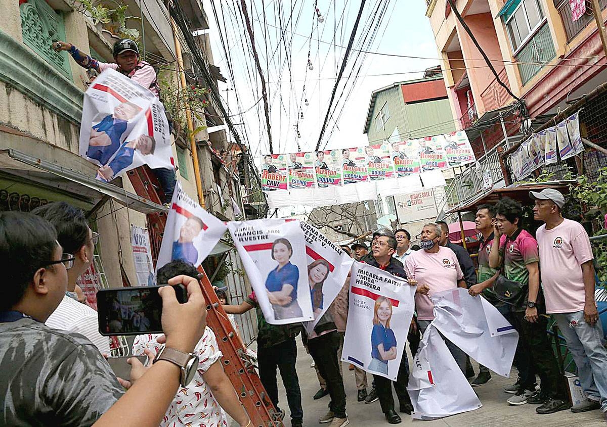 Operation Baklas Commission on Elections Chairman George Erwin Garcia helps remove campaign materials attached to electric posts on Tuesday, Oct. 24, 2023, in Pasay City, as the commission ramped up its drive against illegal campaign materials. PHOTO BY RENE H. DILAN
