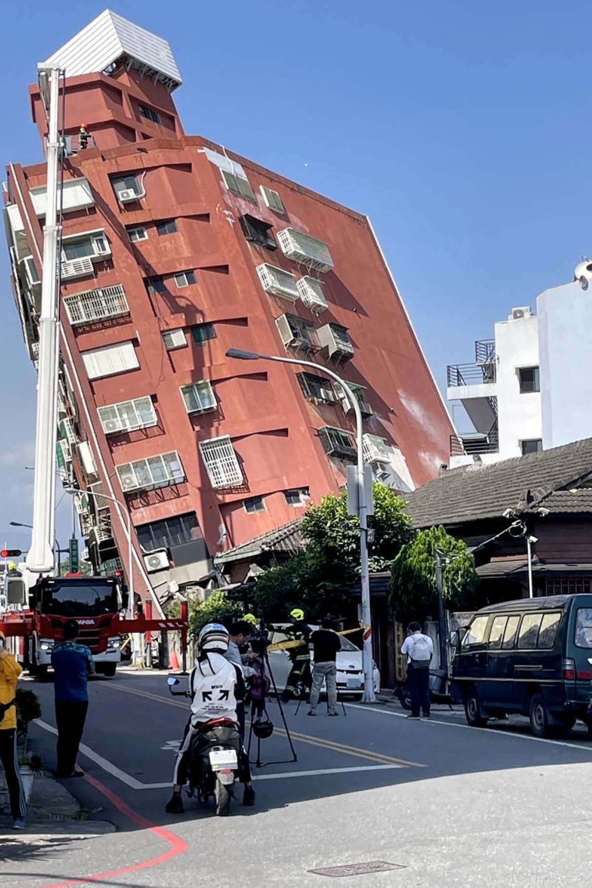 This photo taken by Taiwan's Central News Agency (CNA) on April 3, 2024 shows people looking at a damaged building in Hualien, after a major earthquake hit Taiwan's east. Photo by CNA / AFP