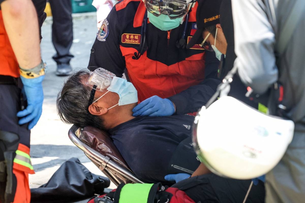 This photo taken by Taiwan's Central News Agency (CNA) on April 3, 2024 shows emergency workers attending to a survivor, who had been trapped in a damaged building, in New Taipei City, after a major earthquake hit Taiwan's east. Photo by CNA / AFP