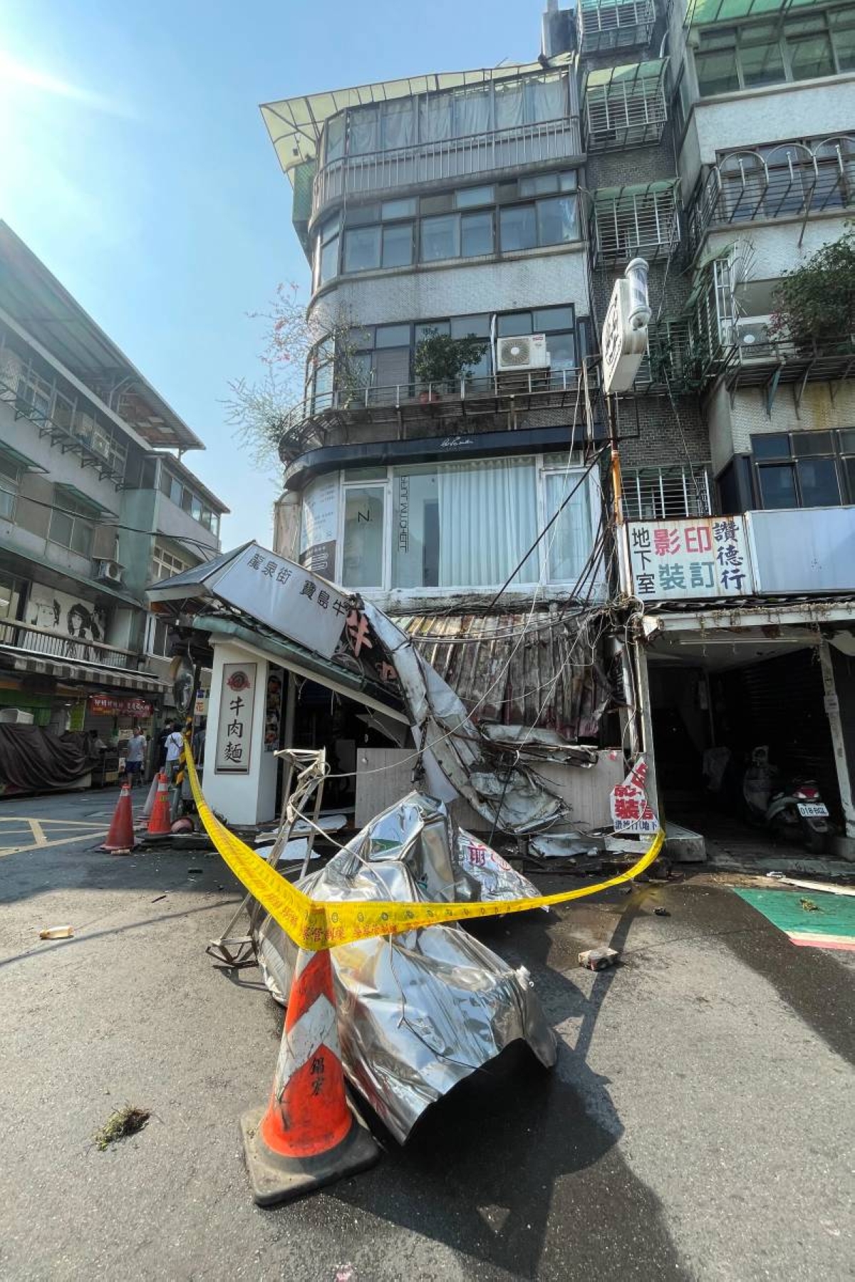 This photo taken by Taiwan's Central News Agency (CNA) on April 3, 2024 shows an area being cordoned off after damage to a building in Taipei, after a major earthquake hit Taiwan's east. Photo by CNA / AFP