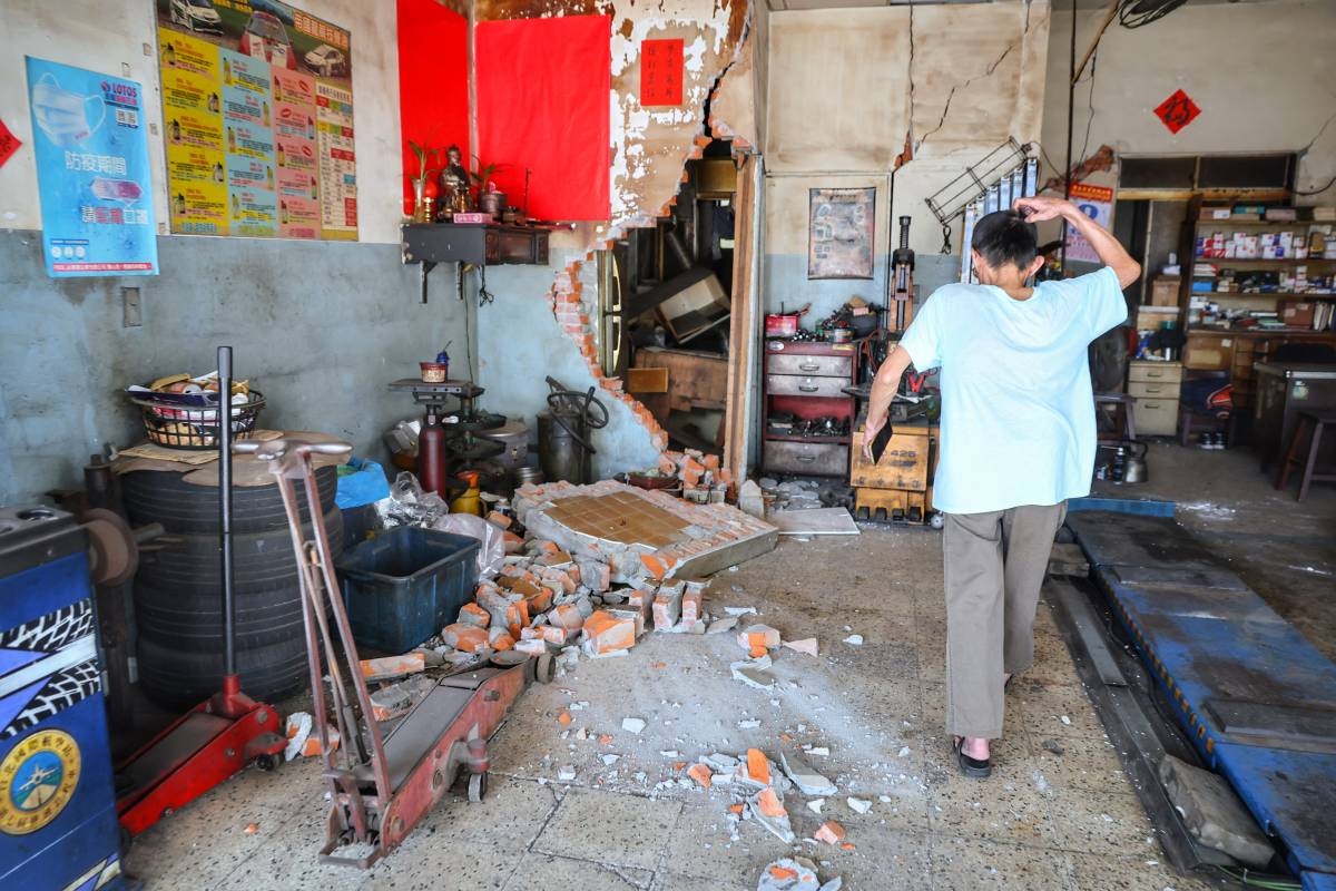 This photo taken by Taiwan's Central News Agency (CNA) on April 3, 2024 shows a man reacting after a brick wall in a house collapsed in Taipei, after a major earthquake hit Taiwan's east. Photo by CNA / AFP