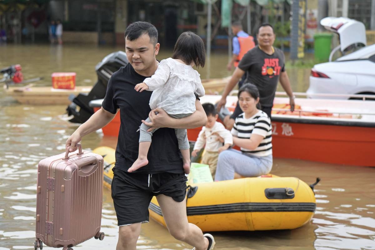 Residents wade through floodwaters after being evacuated from a flooded area following heavy rains in Qingyuan city, in China’s southern Guangdong province on April 22, 2024. AFP PHOTO