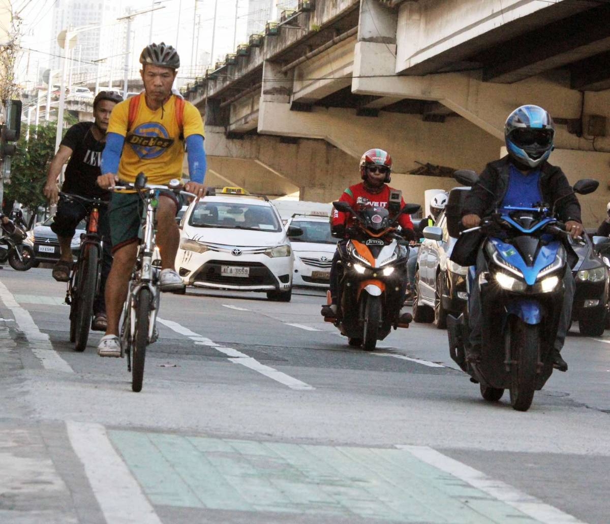 Bicycle riders are seen at the EDSA bike lane in Quezon City on Wednesday, April 24, 2024. The Metropolitan Manila Development Authority (MMDA), along with the Department of Transportation (DOTr), is considering removing the bicycle lane on EDSA to explore the possibility of building a dedicated motorcycle lane. According to the MMDA, only 1,500 cyclists use the bike lane daily compared to 170,000 motorcycles going through EDSA per day.  PHOTOS BY ISMAEL DE JUAN