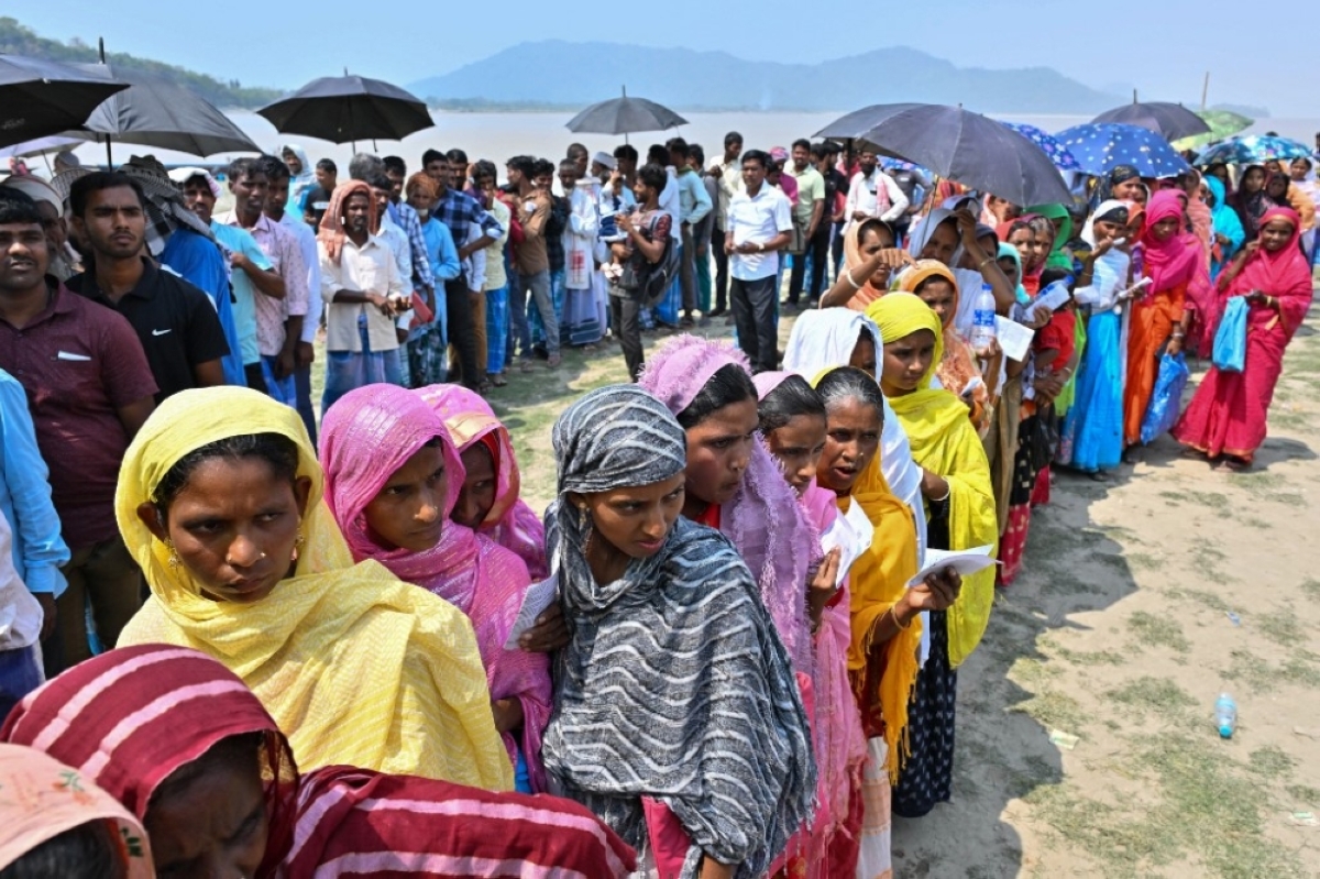 STAND UNDER THE SUN Voters stand in line to cast their ballot outside a polling station during the second phase of voting for India’s general election at Gashbari village, in northeastern Arram state’s Darrang district, on Friday, April 26, 2024. AFP PHOTO