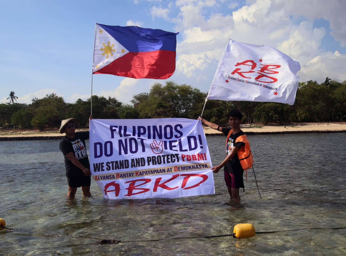 Fisherfolk from Zambales, along with Alyansa Bantay Kapayapaan at Demokrasya, wave a Philippine flag during a fluvial parade in the West Philippine Sea in Candelaria, Zambales, on Saturday, May 11, 2024, to express their condemnation of the harassment by the Chinese Coast Guard of Filipino fishermen. PHOTOS BY ISMAEL DE JUAN