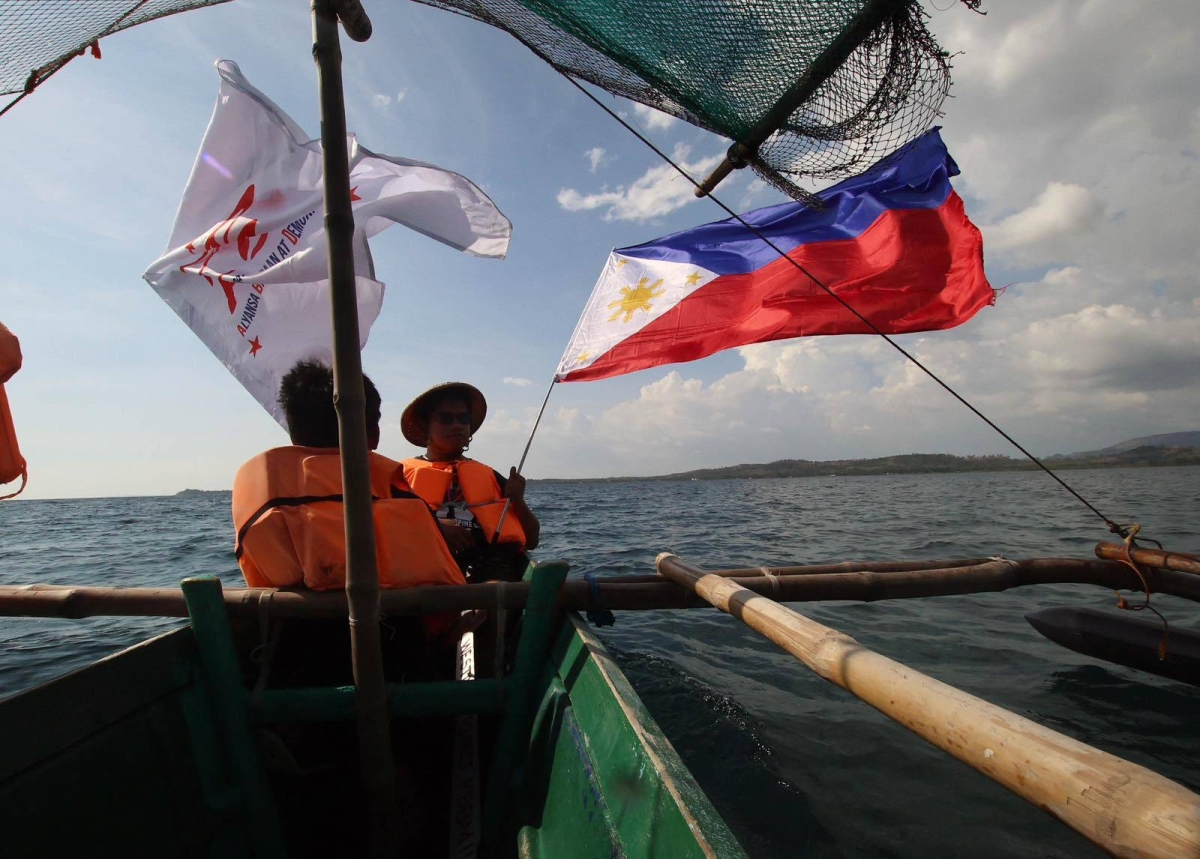 Fisherfolk from Zambales, along with Alyansa Bantay Kapayapaan at Demokrasya, wave a Philippine flag during a fluvial parade in the West Philippine Sea in Candelaria, Zambales, on Saturday, May 11, 2024, to express their condemnation of the harassment by the Chinese Coast Guard of Filipino fishermen. PHOTOS BY ISMAEL DE JUAN 