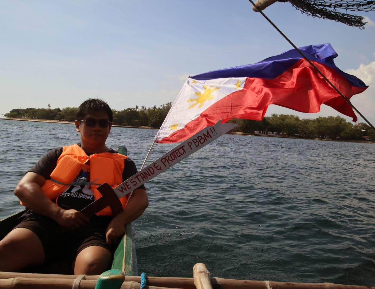 Fisherfolk from Zambales, along with Alyansa Bantay Kapayapaan at Demokrasya, wave a Philippine flag during a fluvial parade in the West Philippine Sea in Candelaria, Zambales, on Saturday, May 11, 2024, to express their condemnation of the harassment by the Chinese Coast Guard of Filipino fishermen. PHOTOS BY ISMAEL DE JUAN 