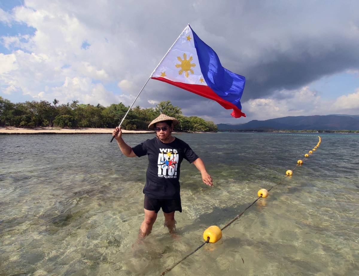 Fisherfolk from Zambales, along with Alyansa Bantay Kapayapaan at Demokrasya, wave a Philippine flag during a fluvial parade in the West Philippine Sea in Candelaria, Zambales, on Saturday, May 11, 2024, to express their condemnation of the harassment by the Chinese Coast Guard of Filipino fishermen. PHOTOS BY ISMAEL DE JUAN 