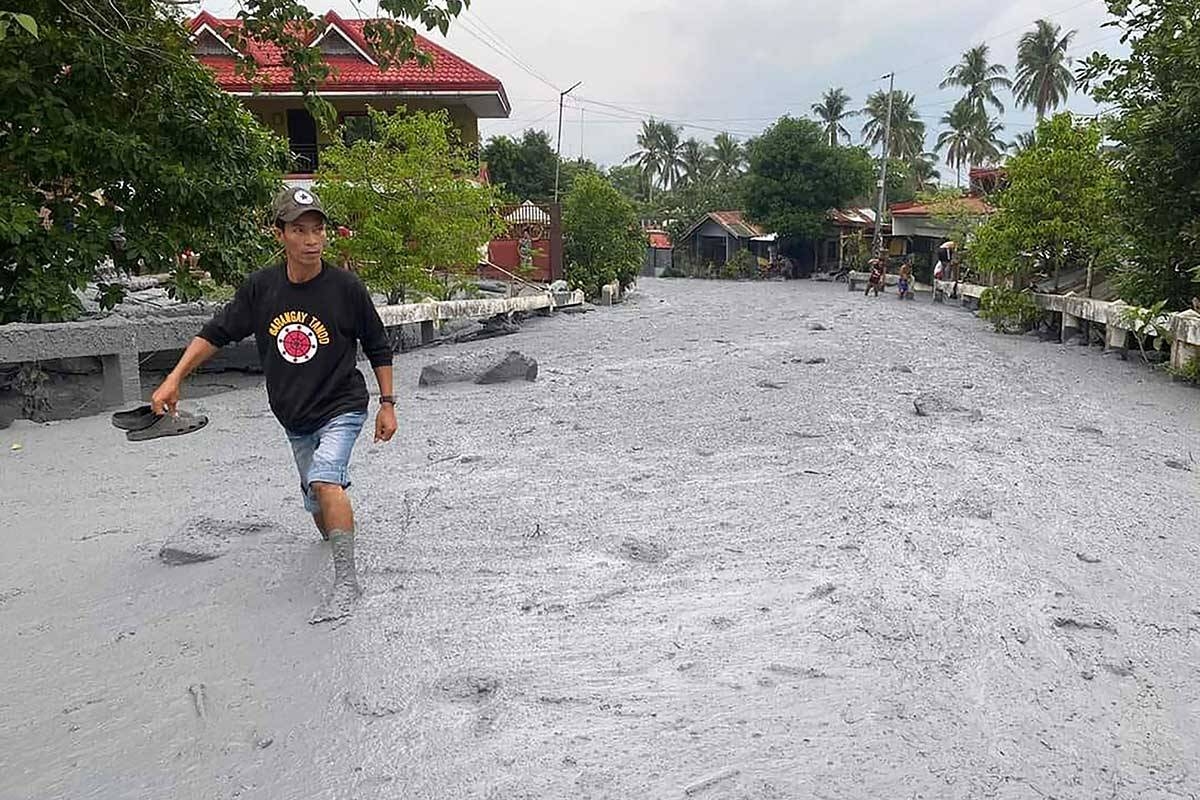 VOLCANIC SLUDGE This handout photo taken and released on June 5, 2024 by the Office of the Protected Area Superintendent of Mount Kanlaon Natural Park shows a resident wading through lahar from the eruption of Mount Kanlaon volcano along a road in Biaknabato village in La Castellana municipality, Negros Occidental province. AFP PHOTO