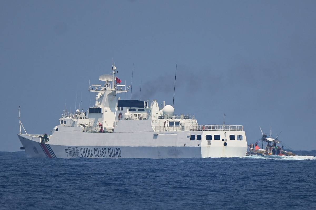 FP MAIN FOTO WITH BANNER
A China Coast Guard ship maneuvers past a Philippine fishing boat during the distribution of fuel and food to fishers by the civilian-led mission Atin Ito (This Is Ours) Coalition in the disputed South China Sea on May 16, 2024. AFP PHOTO