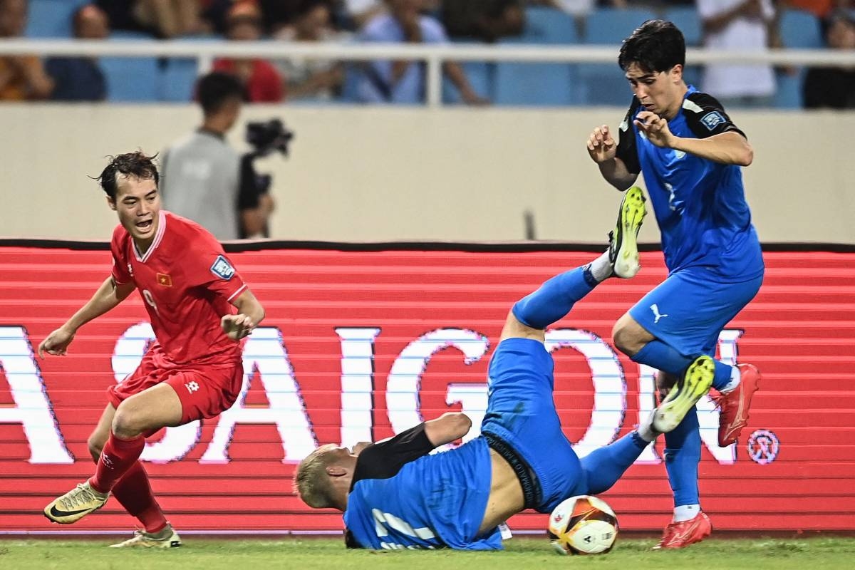 The Philippines' Scott Woods (right) and Vietnam's Nguyen Van Toan (left) react as the Philippines' Adrian Ugelvik falls during the 2026 FIFA World Cup AFC qualifiers football match between Vietnam and the Philippines at the My Dinh National Stadium in Hanoi on June 6, 2024. AFP PHOTO