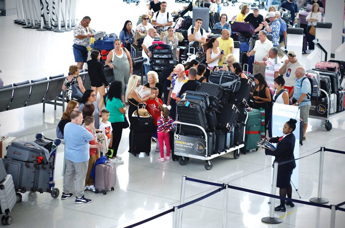 Passengers wait in line at Terminal 1 in John F. Kennedy International Airport one day after a global IT outage, in New York, on July 20, 2024. AFP PHOTO