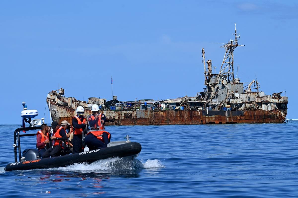 This photo taken on November 10, 2023 shows Philippine coast guard personnel and journalists sailing onboard a rigid inflatable boat (left) as they head back after filming the BRP Sierra Madre docked at Second Thomas Shoal in the disputed South China Sea. AFP PHOTO