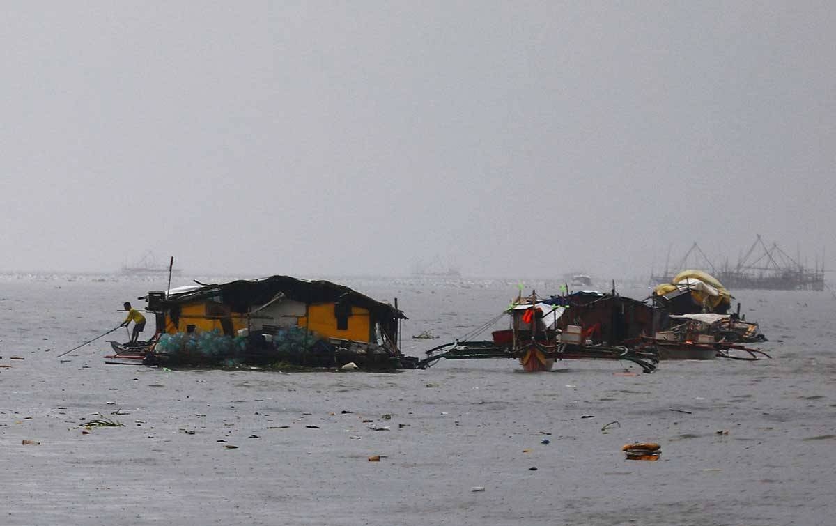 THEY FLOAT Fishermen secure their houses near the Parañaque Fish Market on July 24, 2024. PHOTO BY MIKE ALQUINTO