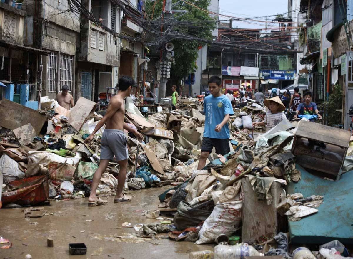 Residents of Barangay Malanday in Marikina City clean and sort their mud-covered belongings on July 25, 2024, a day after their homes were submerged in flood waters caused by the monsoon rains enhanced by Typhoon 'Carina.' PHOTO BY ISMAEL DE JUAN