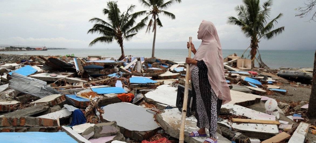 A woman looks across her village in Indonesia which was destroyed in a tsunami. OCHA/Anthony Burke