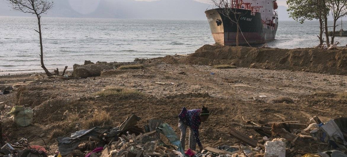 A woman in Indonesia searches through the rubble at a beach in Palu, Indonesia, that was entirely washed away by an October 2018 tsunami. (file) UNICEF/Watson