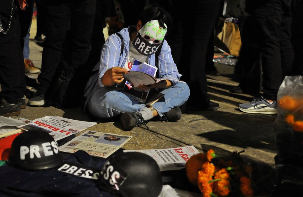 A pro-Palestine demonstrators wearing a skull mask attends a vigil for journalists killed during the Israel-Hamas conflict in Mexico City on October 30, 2024. (Photo by VICTOR CRUZ / AFP)