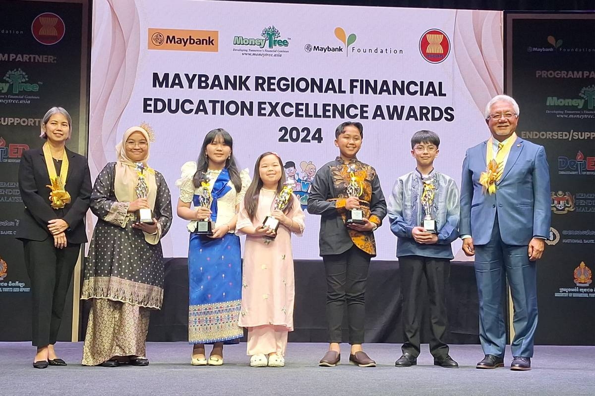 Southeast Asia's Best Students in Financial Literacy with Bangko Sentral ng Pilipinas Regional Operations and Advocacy Sector Financial Inclusion and Consumer Empowerment Sub-sector Managing Director lawyer Charina De Vera-Yap (left) and Maybank Group and Maybank Foundation Chairman Tan Sri Dato' Sri Ir. Zamzamzairani Mohd Isa (right). PHOTOS BY ARLO CUSTODIO