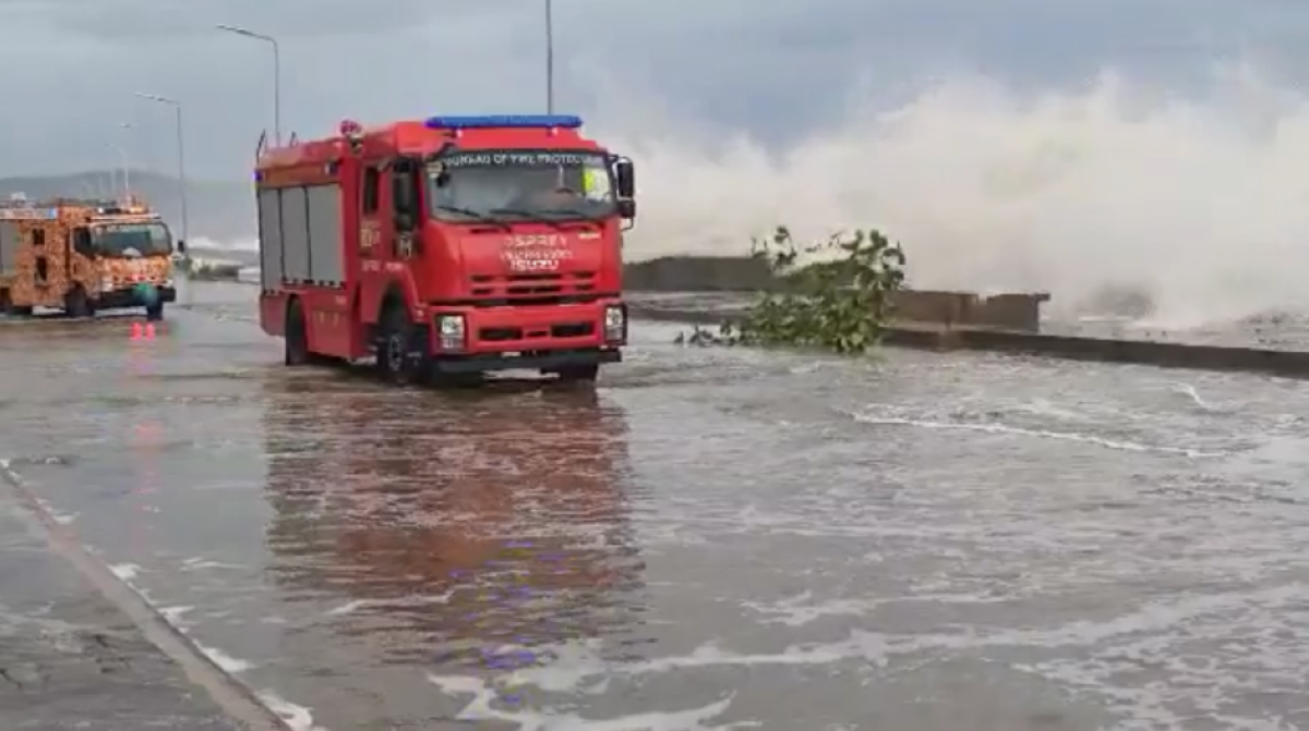 A storm surge hits Catanduanes Boulevard as the Bureau of Fire Protection arrive to help coastal residents evacuate to a safer place. PHOTO BY RHAYDZ BARCIA