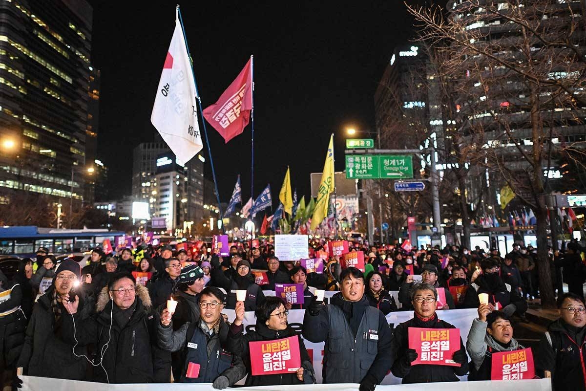 Protesters take part in a march against South Korea President Yoon Suk Yeol as they head toward the National Assembly in Seoul on December 4, 2024. Thousands of protesters marched through central Seoul on December 4, AFP journalists saw, chanting and waving placards demanding the president step down after briefly imposing martial law and plunging South Korea into political chaos. (Photo by Philip FONG / AFP)