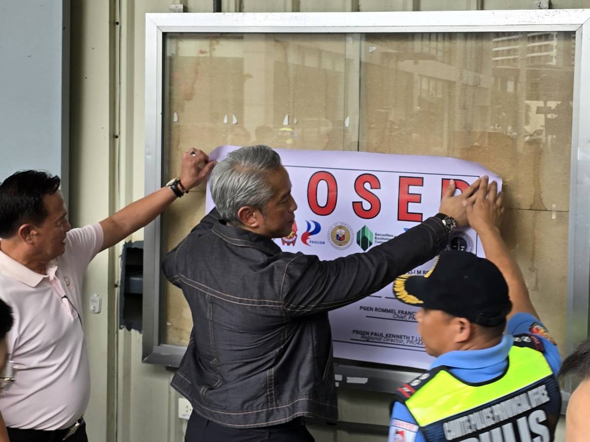 CLOSED Interior Secretary Jonvic Remulla places a notice at the main entrance of one of the buildings at Covelandia in Kawit, Cavite, to certify the shutdown of the POGO facility in the area on Dec. 17, 2024. PHOTO BY DENNIS ABRINA