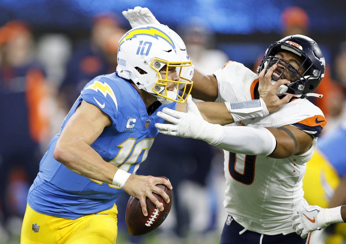 STIFF ARM Justin Herbert (left) of the Los Angeles Chargers stiff arms Jonathon Cooper of the Denver Broncos during the fourth quarter in the game at SoFi Stadium on Dec. 19, 2024, in Inglewood, California. AFP PHOTO