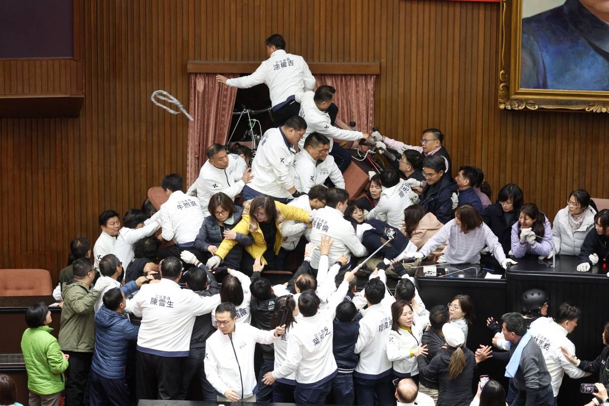 FREE-FOR-ALL Lawmakers from the opposition Kuomintang (KMT) try to break into Parliament, where Democratic Progressive Party (DPP) occupied the night to avoid the passing of third reading of amendments to the Civil Servants Election and Recall Act and other controversial bills in Taipei, on Dec. 20, 2024. AFP Photo