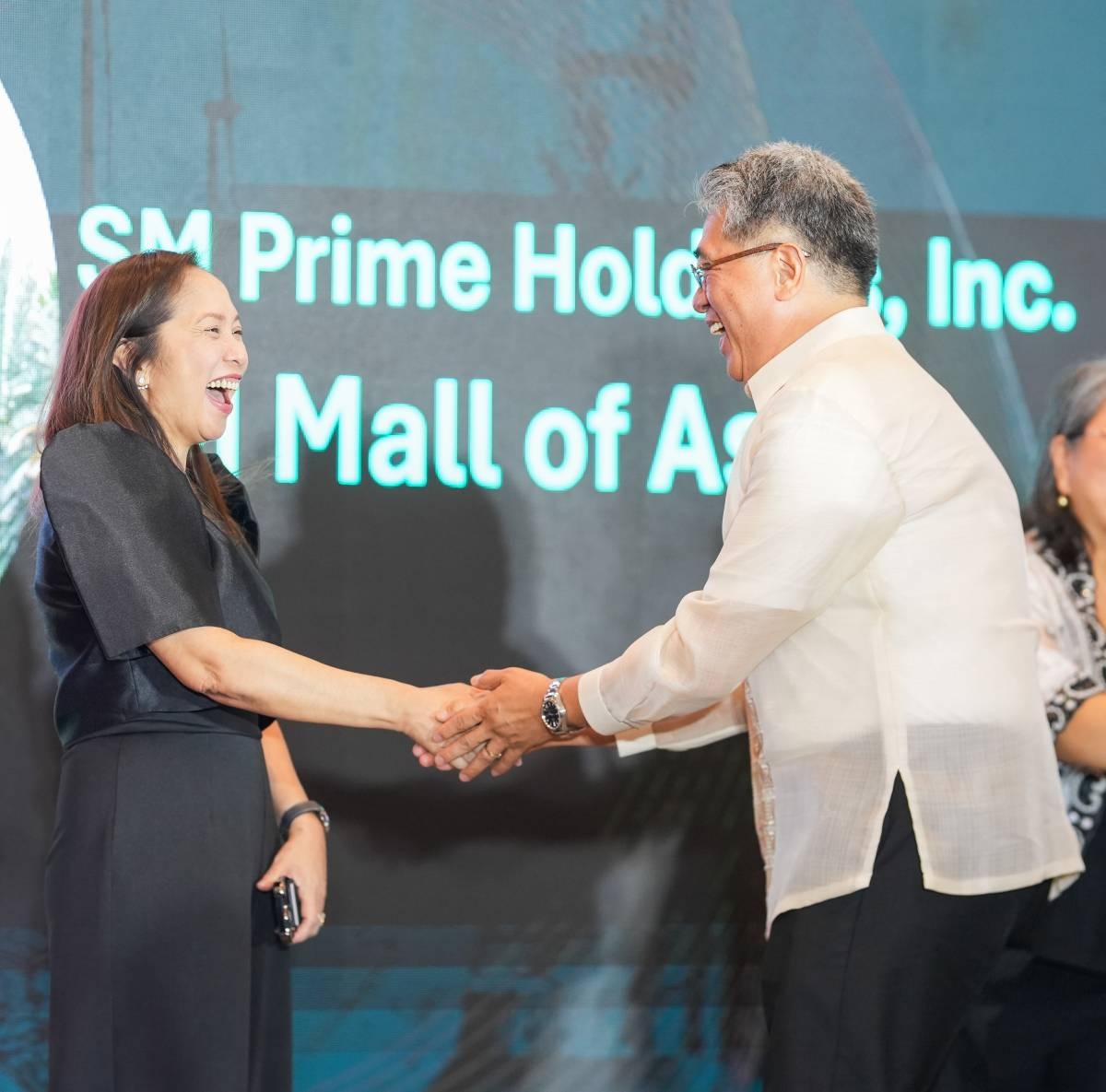 Department of Energy Undersecretary Sharon Garin (left) congratulates SM Engineering Design and Development Vice President for Operations Engr. Teodoro Bautista for SM Mall of Asia’s win of the first DOE Sustainable Energy Award for private institutions. PHOTO FROM SM PRIME