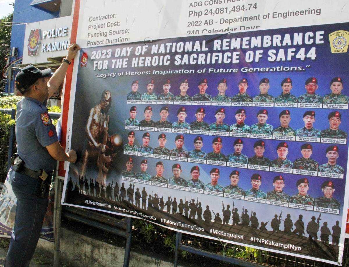 REMEMBERING SAF 44 A policeman from the Quezon City Police District Station 10 puts up a tarpaulin bearing the faces of the 44 fallen Special Action Force commandos on Wednesday, Jan. 25, 2023, the day they were massacred in a battle with Muslim extremists in Mindanao in 2015. PHOTO BY MIKE DE JUAN