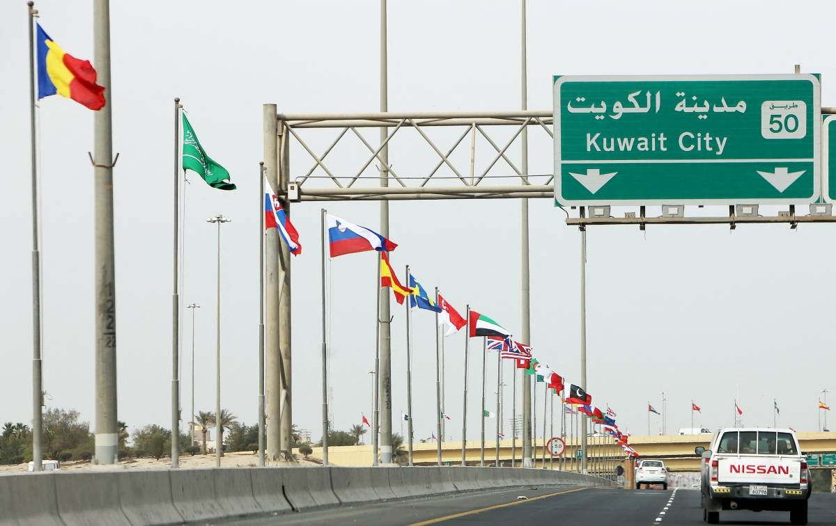 A picture taken on February 9, 2018 shows flags of the 70 countries participating in the Kuwait International Conference for Reconstruction of Iraq, flying along a highway in the capital Kuwait City. AFP PHOTO