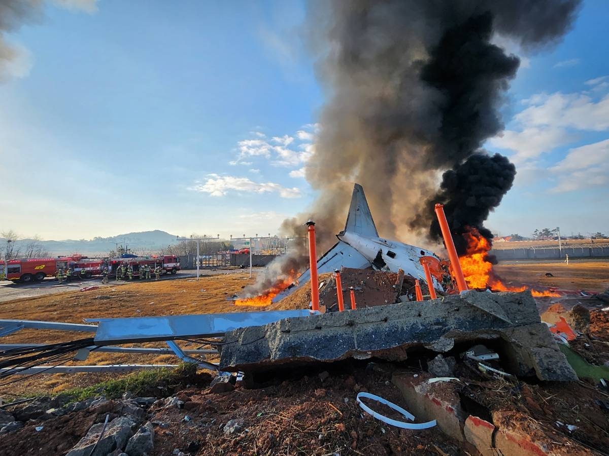 FIERY WRECK Fire and smoke rise from the tail section of a Jeju Air Boeing 737-800 series aircraft after the plane crashed and burst into flames at Muan International Airport in South Jeolla province, some 288 kilometers southwest of Seoul, on Dec. 29, 2024. PHOTO BY YONHAP VIA AFP