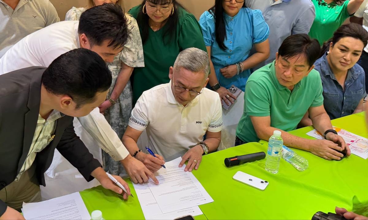 FIGHT IS ON Former Mandaue City mayor Jonas Cortes (center) signs the temporary restraining order (TRO) delivered by the court’s sheriff during a press conference on Jan. 21, 2025. The TRO rekindled Cortes’ mayoral bid this May. Also in photo are (from left) lawyers Joshua Monsanto and Joselito Baena of Rama Baena Tan & Ang Law, Mandaue City Mayor Glenn Bercede, and congressional candidate and former city treasurer Regal Oliva. PHOTO BY KAISER JAN FUENTES