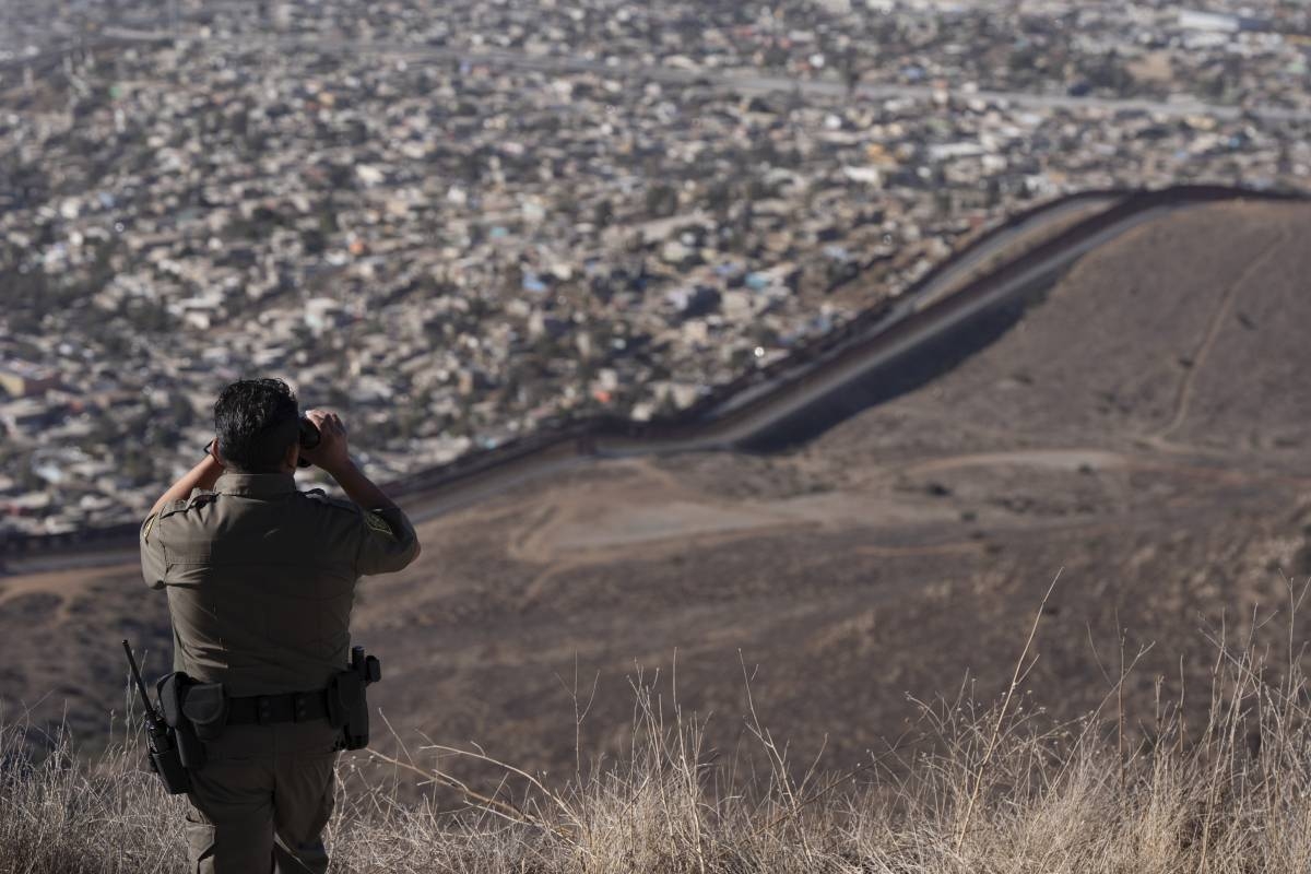 Border Patrol Agent Gutierrez looks through binoculars towards two border walls separating Mexico from the United States, Thursday, Jan. 23, 2025, in San Diego. (AP Photo/Gregory Bull)