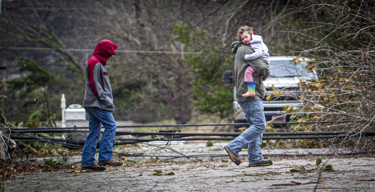 A man carries a little girl to a truck from a house amidst debris from a storm in east Tuscumbia, Ala., Sunday, Feb. 16, 2025. PHOTO BY DAN BUSEY/ THE TIMES DAILY VIA AP 