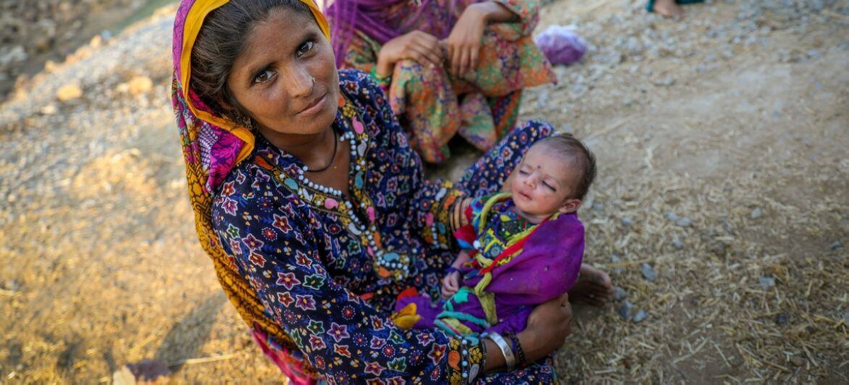 A family take refuge on a roadside in Jacobabad district, Pakistan, after fleeing their flood-hit home. UNICEF/Asad Zaidi