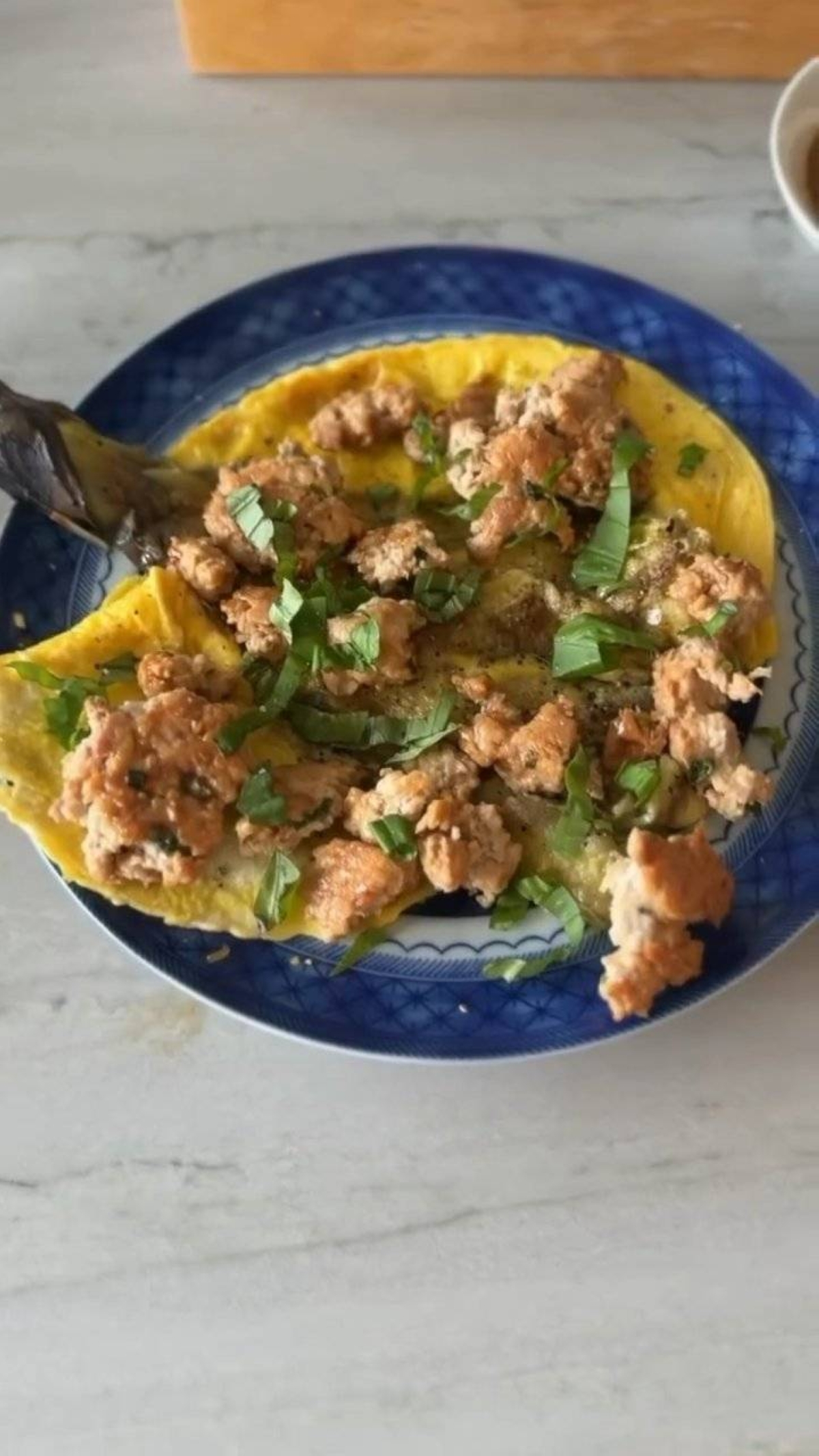 The finished dish featured a golden egg base topped with browned turkey crumbles and fresh green herbs.